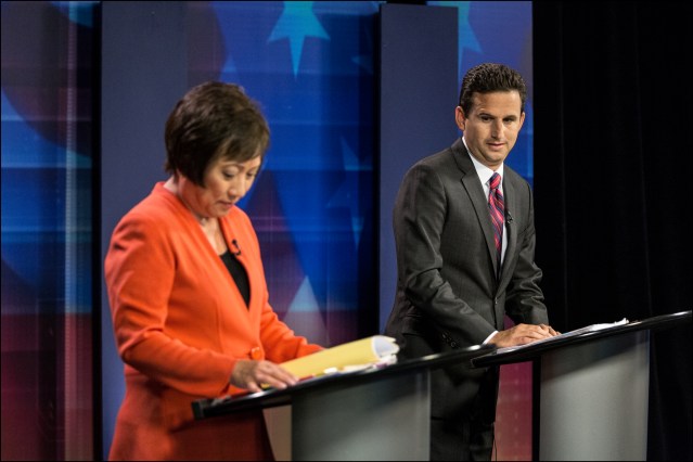 Checking it Out. Brian Schatz takes a look at Colleen Hanabusa's briefing book just before airtime of their televised debate in the KITV studios on July 7, 2014.