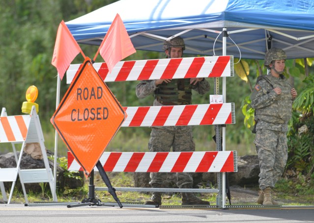 Members from the Task Force Response Army and Air National Guard personnel stand at road block at Pahoa Village Road and Post Office Road only allowing residents that live in the area passage. No media are allowed within this road blocked areas.  30 October 2014. photo Cory Lum