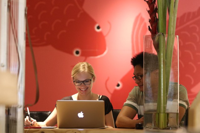 Left, Judith Bises and Marlon Sarmiento from 50/50 Agency work at the BoxJelly in Kakaako.  25 march 2015. photograph cory Lum/CIvil Beat