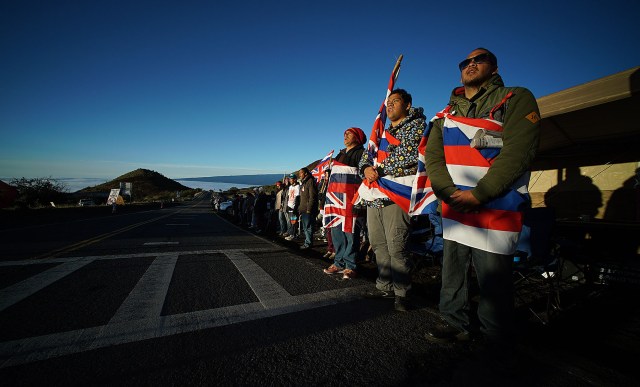 Flag draped Mauna Kea supporters bathe in the sunrise. 10 april 2015. photograph Cory Lum/Civil Beat