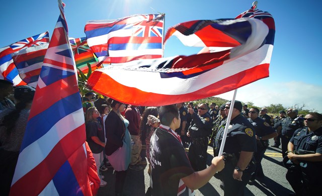 Mauna Kea demonstrators line the access road holding flags as DLNR law enforcement officers head up the mountain on foot. 24 june 2015. photograph Cory Lum/Civil Beat