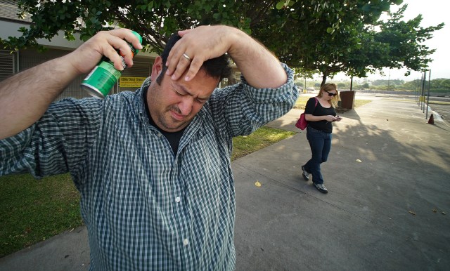 Colleague Engagement Editor Anthony Quintano loads up on the 'Deet' spray while waiting for Civil Defense and other Hawaii county officials to meet media.