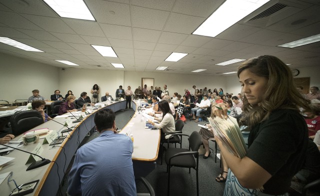 Standing room only during joint house/senate committee meeting as right, Representative Andria Tupola and Rep Karl Rhoads move out of way of staff in room 016 Capitol. 25 april 2016