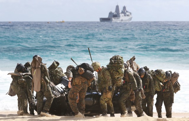 Provisional Marine Expeditionary Brigade-Hawaii (PMEB-HI), made up primarily of III Marine Expeditionary Force units based in Hawaii and The Japan Ground Self-Defense Force members were conducting the landing with Company E, Battalion Landing Team 2nd Battalion assist in carrying inflatable boat on shore Pyramid Rock Beach during RIMPAC amphibious exercises. 30 july 2016