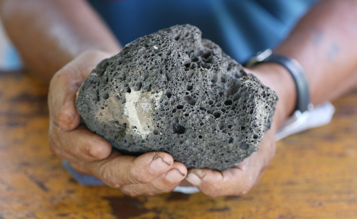 Pagan Resident Pedro Castro holds pumice that blasted out of the volcano. 27 aug 2016