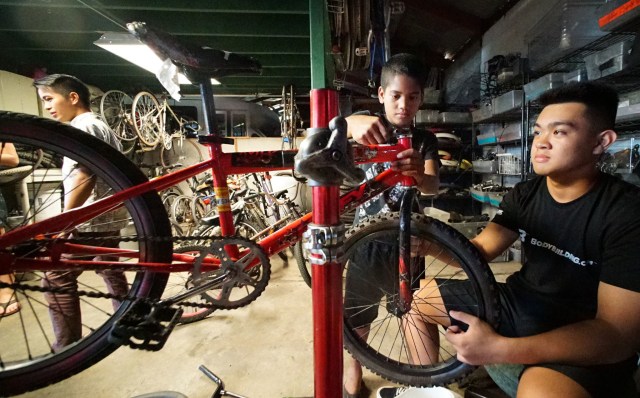 Right, KVIBE senior intern, 15-year-old Randell Dejesus from Farrington HS assists 10-year-old Wally Jakabot at the Kalihi Valley Instructional Bicycle Exchange Program. 26 oct 2016