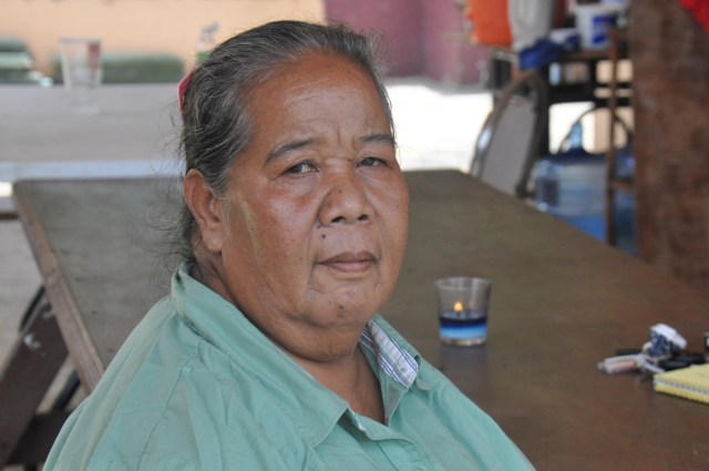 Clotilde Aldan sits outside her house on Saipan. She says she wants her grandchildren to be able to live on Pagan. 