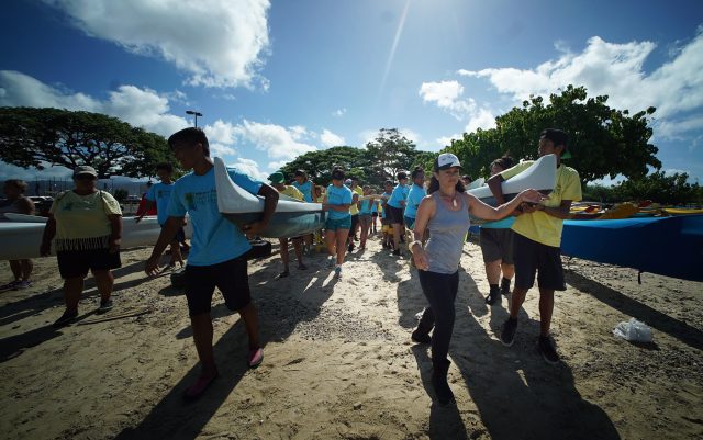 Kehaulani Kupihea directs Waianae students on moving canoe to the water at Sand Island before embarking to Mokauea Island.