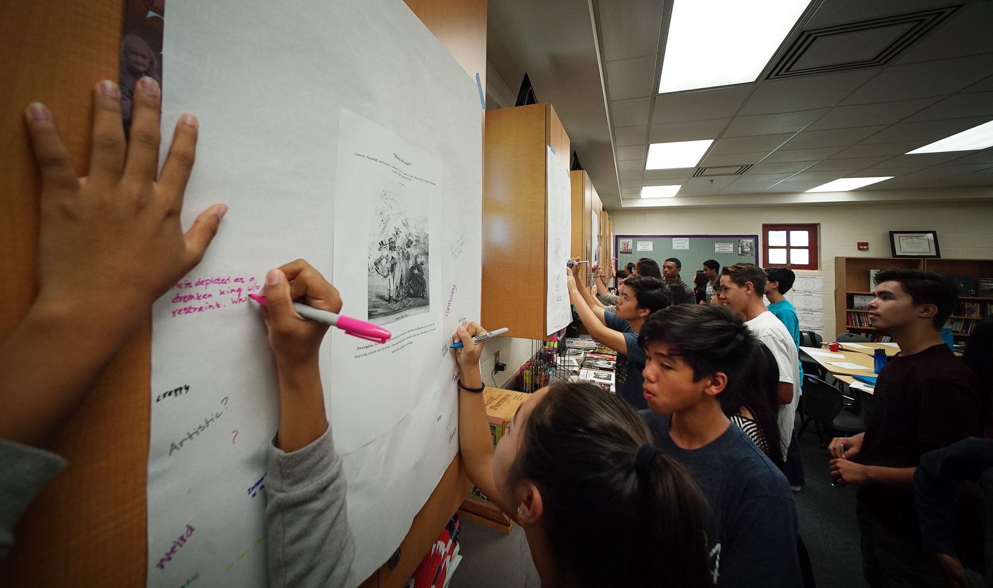 9th graders in Mililani High School's, Mrs. Amy Perruso social studies class write comments and observations on 2 cartoons of King David Kalakaua in the late 1800s.