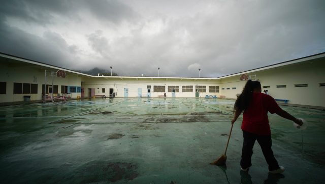 Silhouetted Womens Community Correctional Center inmate sweeps the inner courtyard area of the womens prison. WCCC is locafed on the windward side of Oahu.