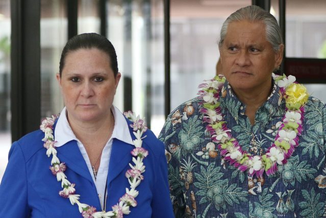 Retired HPD Chief Louis Kealoha and Katherine Kealoha bedecked with lei as they exit US District Court.