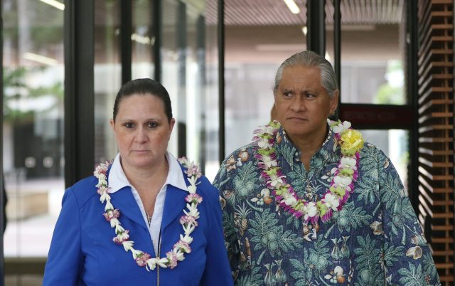 Retired HPD Chief Louis Kealoha and Katherine Kealoha bedecked with lei as they exit US District Court.