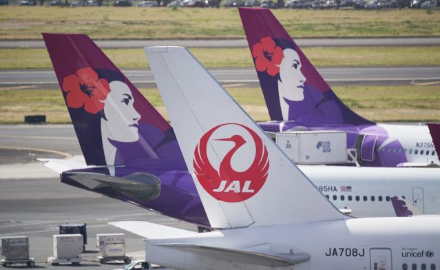 JAL Japan Airlines jet and Hawaiian Airlines sit at Daniel Inouye International Airport.