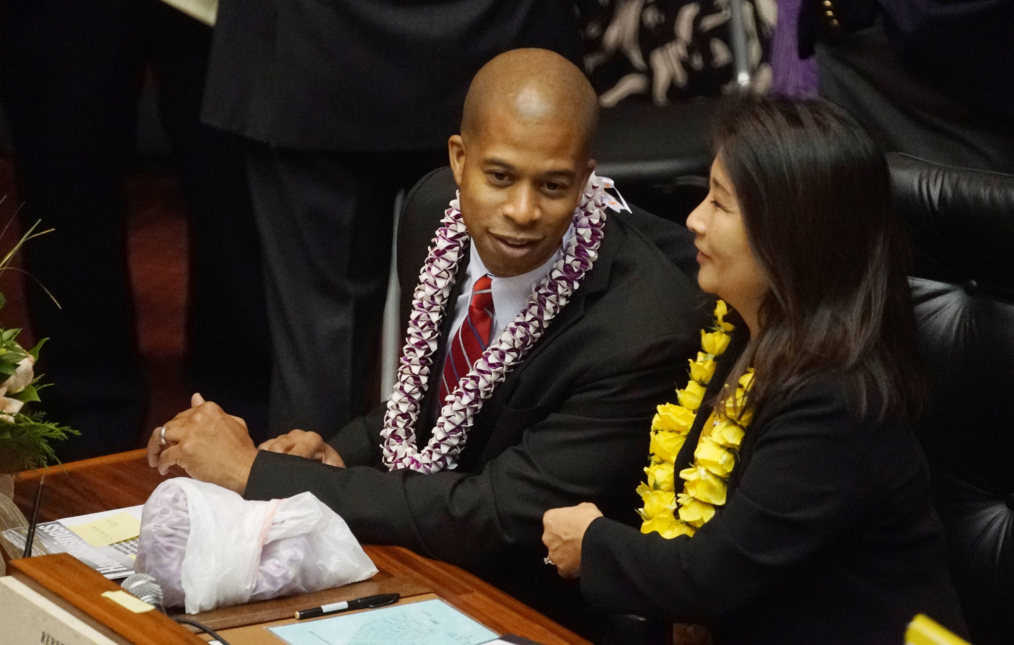Rep Justin Woodson chats with Rep Sylvia Luke before State of State on the House floor.