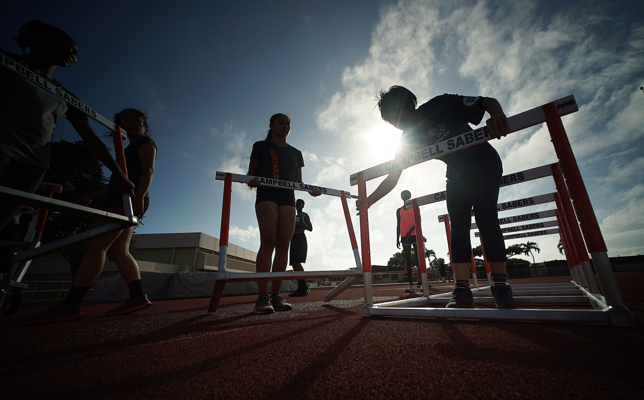 Campbell HS female track track runners prepare some practice gear during practice near the football field.