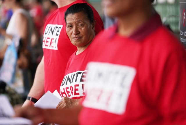 Imaculata Afituk hands out leaflets asking the public for support for United Airlines food workers to unionize at Daniel Inouye International Airport, United curbside area.