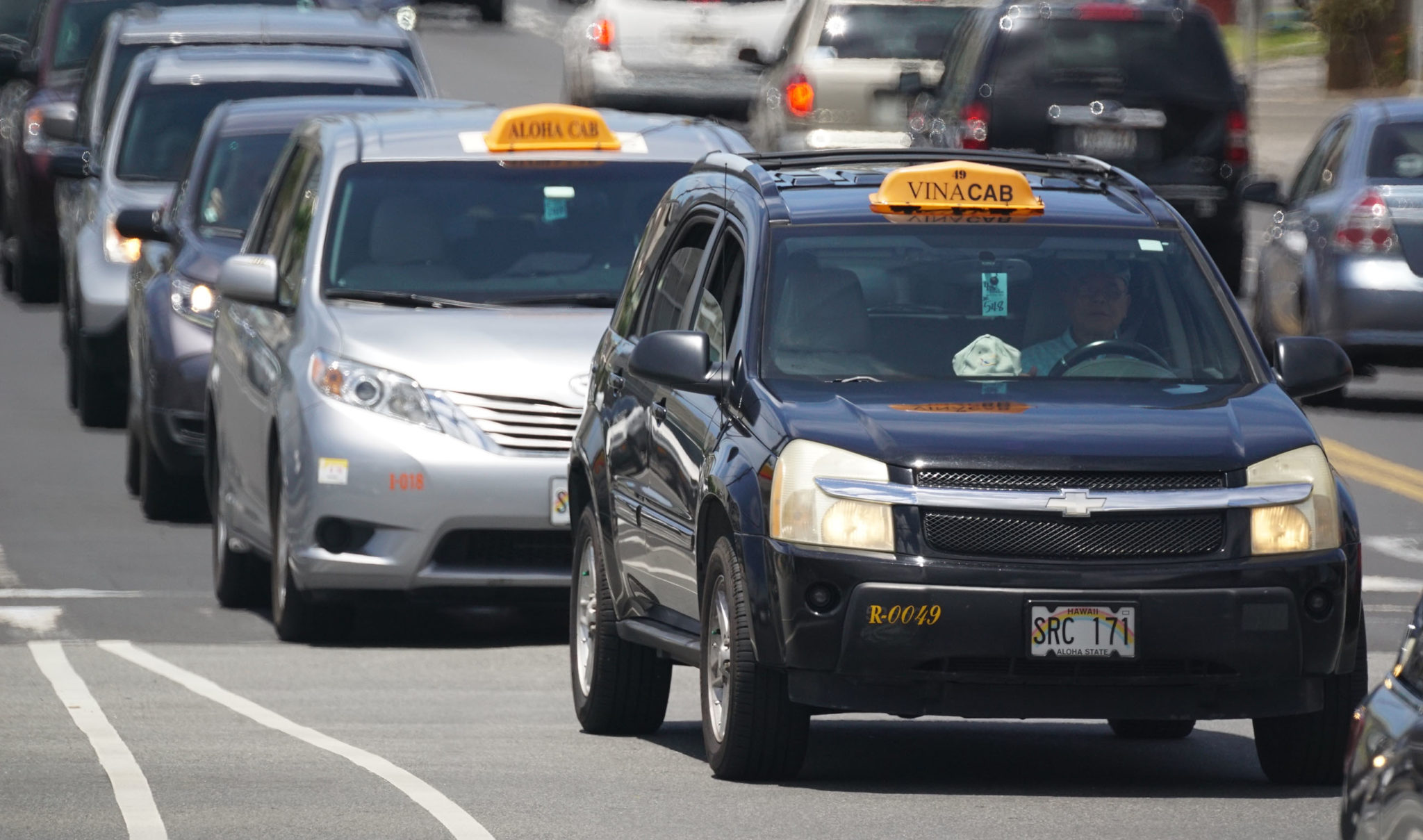 Taxis head up McCully street towards the freeway onramp on a busy morning.