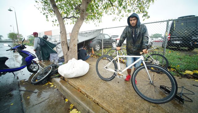 Kakaako park Maruo Lee stands with fixie bike during Tropical Storm Olivia while standing on Ohe Street.