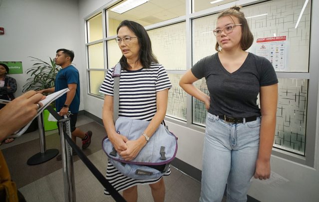 Andrea Bender with her daughter, right, 16-year-old Emily Bender stand in line at the Kapalama Driver License Office of Honolulu.