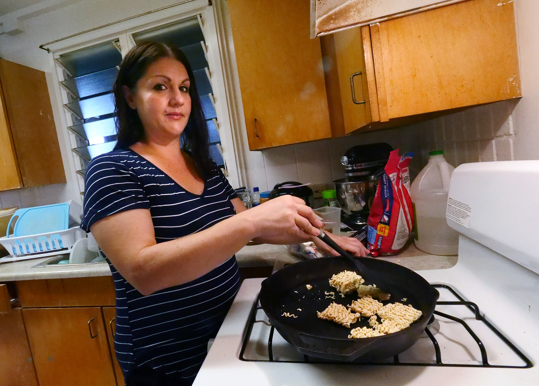 Amber Reynolds cooks a snack in her kitchen Friday, November 16, 2018. Reynolds says that cooking helps to relax her and cope with stress. (Civil Beat photo/Ronen Zilberman)
