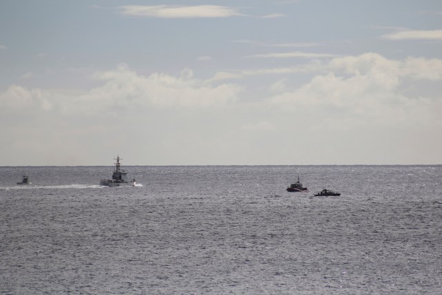 A U.S. Coast Guard vessel and other rescue boats respond to a plane crash off Honolulu, Wednesday, Dec. 12, 2018. Federal Aviation Administration spokesman Ian Gregor said a Hawker Hunter jet went down in the ocean around 2:25 p.m. after taking off from Honolulu's airport. A civilian contractor for the Hawaii Air National Guard who was participating in a military exercise survived after his plane crashed off the coast of Honolulu, authorities said Wednesday. U.S. Coast Guard spokeswoman Petty Officer Sara Muir said the pilot is in stable condition after being rescued about 3 miles south of Oahu near Honolulu's Sand Island. (AP Photo/Caleb Jones)