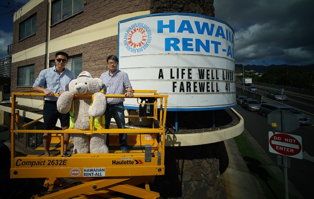 Nathan Oh with right, Scott Jung in portrait with Hawaiian Rent All’s mascot center, Rentie fronting their sign board located at McCully Street and South Beretania Street.