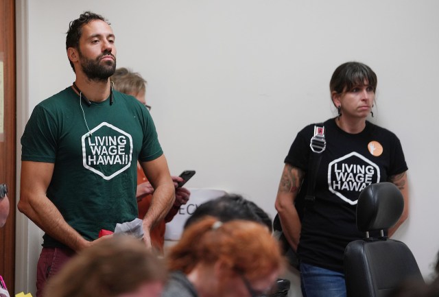 Supporters wearing Living Wage Hawaii shirts listen to Labor committee hearing.