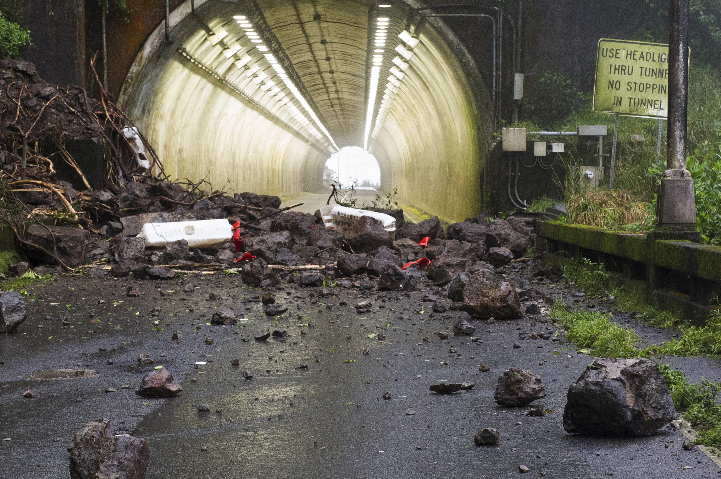 Rocks and debris from a landslide that hit a vehicle are shown on the Pali Highway in Honolulu, Tuesday, Feb. 19, 2019. State transportation officials were assessing the unstable slope above the busy highway after the landslide sent three people to the hospital on Monday. The highway, which connects Honolulu and the east side of Oahu over a steep mountain range, was completely closed and portions will remain shut down all week after multiple landslides in the area. (Craig T. Kojima/Honolulu Star-Advertiser via AP)