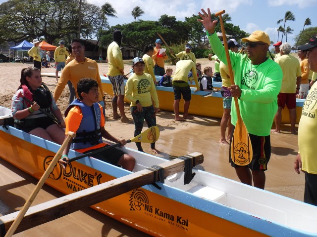 A volunteer instructs kids on how to hold their paddles as they prepare to launch an outrigger canoe into the ocean at the Poka'i Bay Beach Park Saturday, April 14, 2019. Children are taught three main concepts based on the acronym, KAI: Know your limits, Ask a lifeguard, and Identify hazards, so they will learn to enjoy ocean activities safely. (CivilBeat photo Ronen Zilberman)