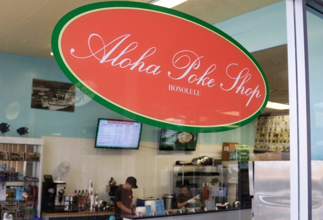This Tuesday, April 16, 2019, photo shows Aloha Poke Shop, a store in Honolulu that received a letter from Chicago-based Aloha Poke Co. saying the Illinois company had trademarked "Aloha Poke" and the Hawaii company would need to change its name. Hawaii lawmakers are considering adopting a resolution calling for the creation of legal protections for Native Hawaiian cultural intellectual property. (AP Photo/Audrey McAvoy)