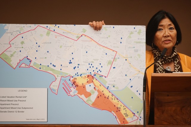 Senator Sharon Moriwaki holds a map showing some vacation rentals in her district.