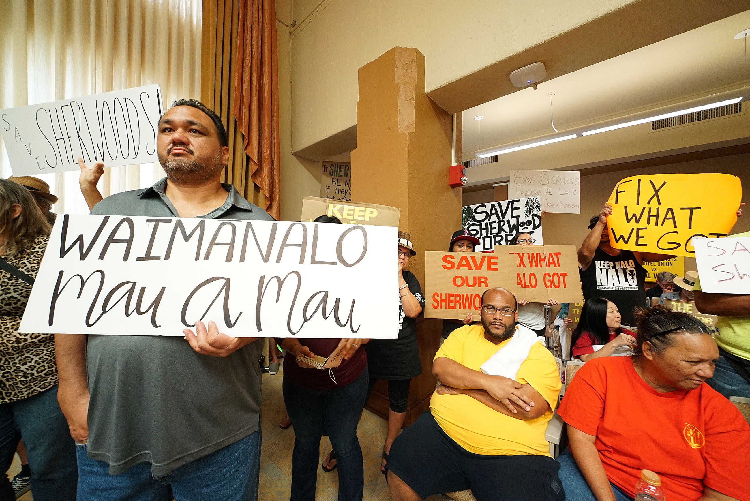 Waimanalo Sherwood Forest Demonstrator Kalani Kalima stands at Honolulu City Council meeting.