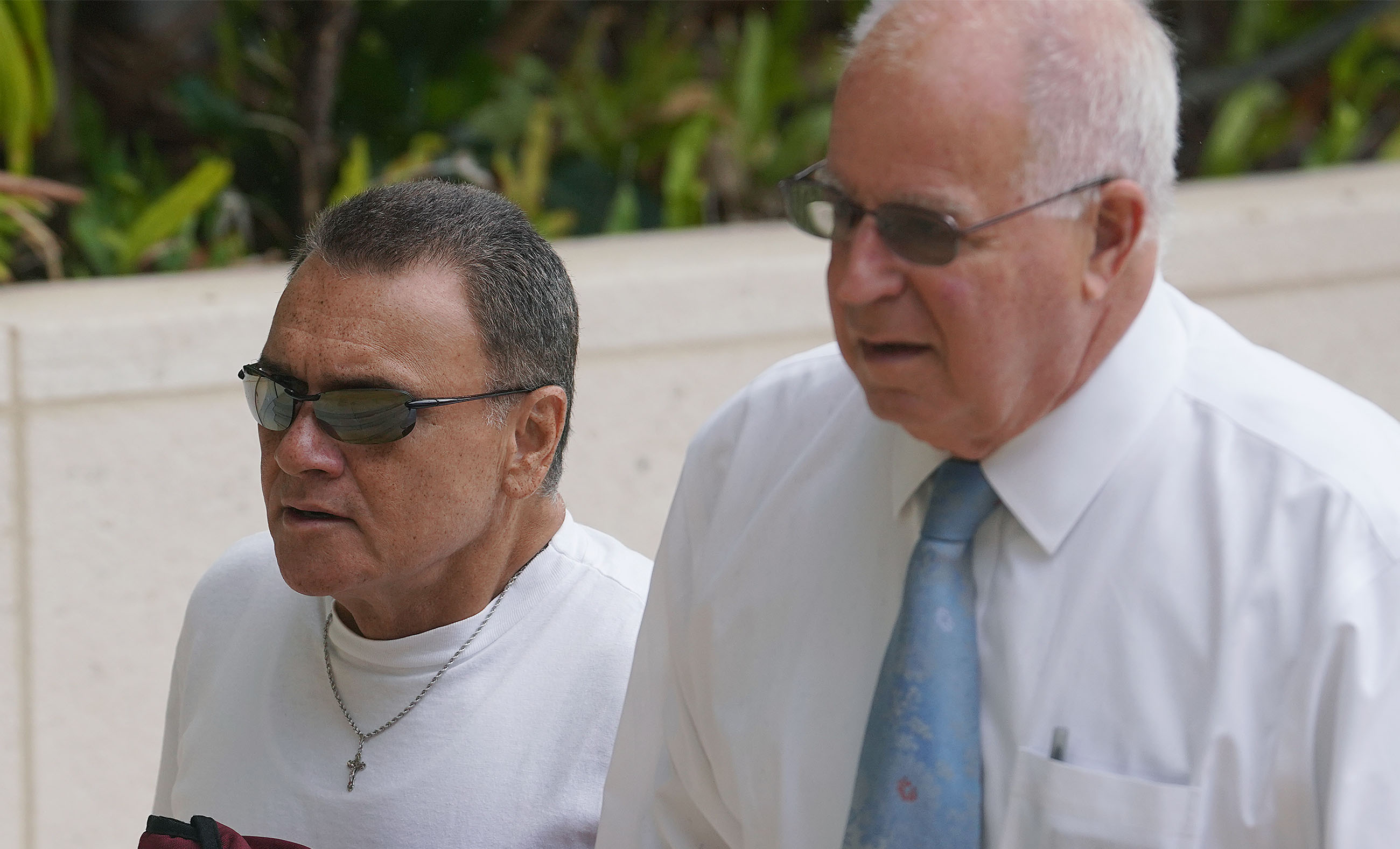 Left, Gerard Puana walks with Eric Seitz on arrival at District Court.