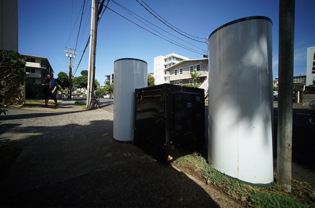 Two water heaters and a refrigerator sit on the sidewalk along Kewalo Street.