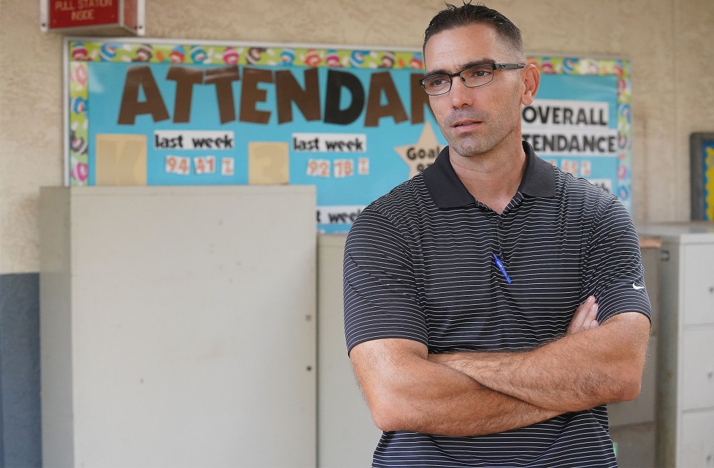 Waipahu Elementary School Vice Principal James Suster stands in front of attendance board.