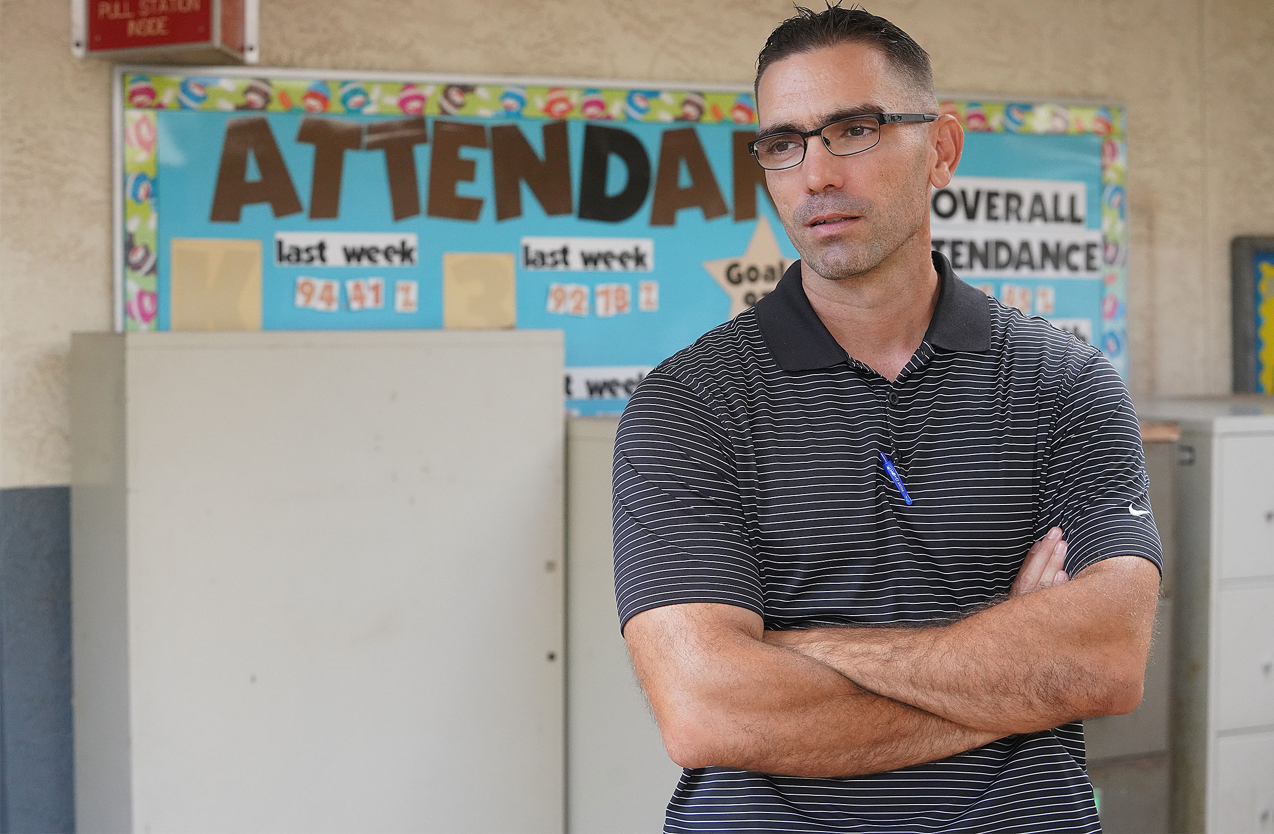 Waipahu Elementary School Vice Principal James Suster stands in front of attendance board.