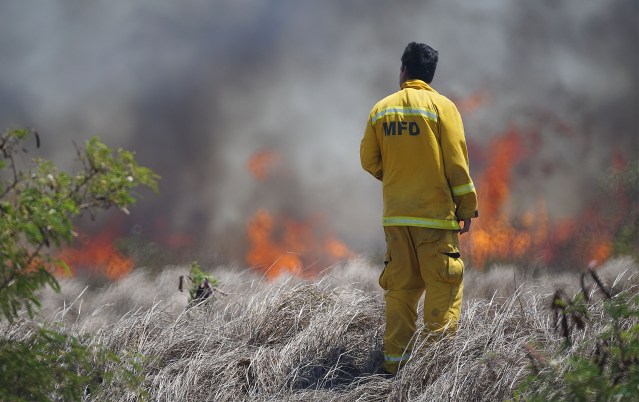 Maui firefighter watches brush fire along Pulehu Road, Maui.