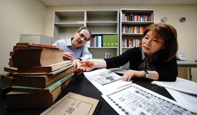 Dr. Andrew Wertheimer PhD and Dr. Noriko Asato, PhD both UH Library professors with some copies of old Hakubundo Japanese bookstore advertisements they found through their research.