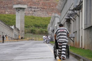 Halawa Correctional Facility inmate pushes empty wheelchair back to module.