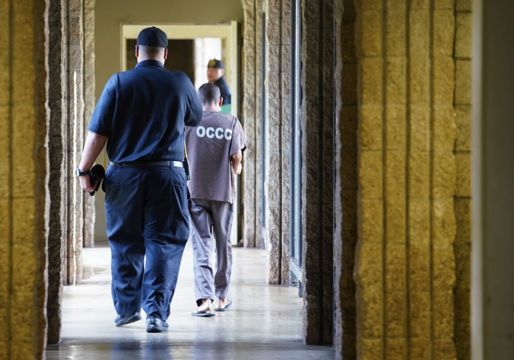 Oahu Community Correctional Center media tour 2019 inmate walks down hall between modules.
