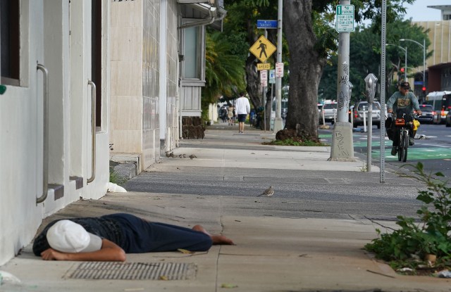 Person sleeps along King Street out of the rain. Homeless