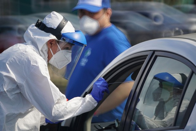 Medical staff removes swab from nose of person being tested for Coronavirus at Waianae Boat Harbor. April 9, 2020.