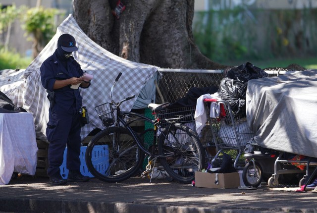Honolulu Police Department cites houseless/homeless along King Street near Moiliili Field during Coronavirus COVID-19 pandemic. April 17, 2020.