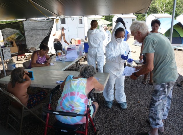Volunteers from the the COVID Command Mobile Unit, of the Premier Medical Group Hawaii, have residents from Hui Mahi'ai Aina community fill-out forms so they can recieve free COVID-19 nose swab tests in Waimanalo, HI, on Sunday, April 26, 2020. (Ronen Zilberman photo Civil Beat)