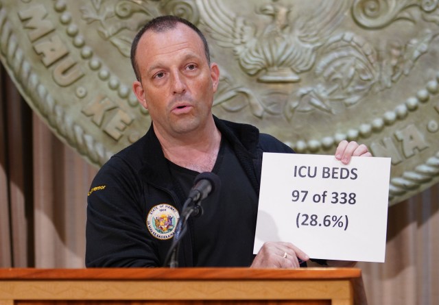 Lt Governor Josh Green holds placard ‘ICU Beds 97 of 338 (28.6%) during Coronavirus COVID-19 press conference held at the Capitol. April 8, 2020.