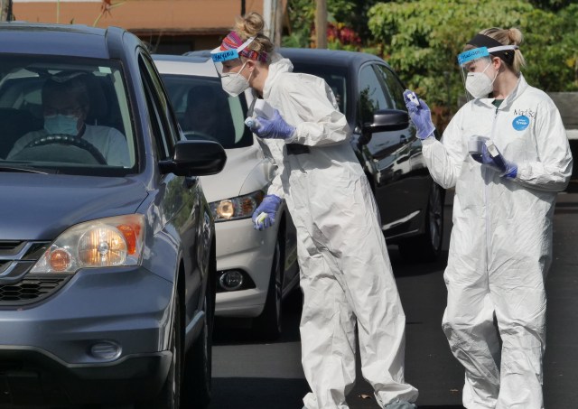Volunteers from the the COVID Command Mobile Unit, of the Premier Medical Group Hawaii, screen everyone as they arrive to the free drive through testing event in Wahiwa,HI on Wednesday, April 22, 2020. (Ronen Zilberman photo Civil Beat)