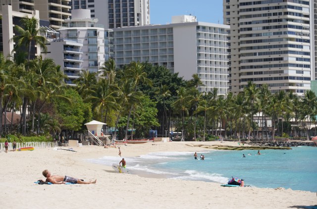 Lone sun bather on Waikiki beach during worldwide Coronavirus pandemic.