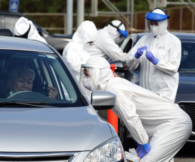 Volunteers from the the COVID Command Mobile Unit, of the Premier Medical Group Hawaii, screen and and perform nose swab tests on Waimanalo residents who came for the free drive through testing event on Sunday, April 26, 2020. (Ronen Zilberman photo Civil Beat)