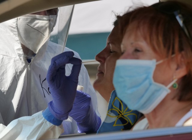 A volunteer from the the COVID Command Mobile Unit, of the Premier Medical Group Hawaii, performs a nose swab test for Waimanalo residents that came to the free drive through testing event Sunday, April 26, 2020. (Ronen Zilberman photo Civil Beat)