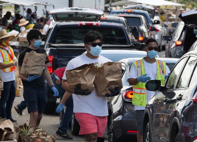 Volunteers were busy loading bags of groceries into cars for hours as thousands showed up for a food distribution event held at Aloha Stadium in Honolulu, HI, Wednesday, May 6, 2020. The city of Honolulu, Hawaii Foodbank, and Hawaii Community Foundation collaborated to put on the event providing food for approximately 4,000 Oahu households. (Ronen Zilberman photo Civil Beat)